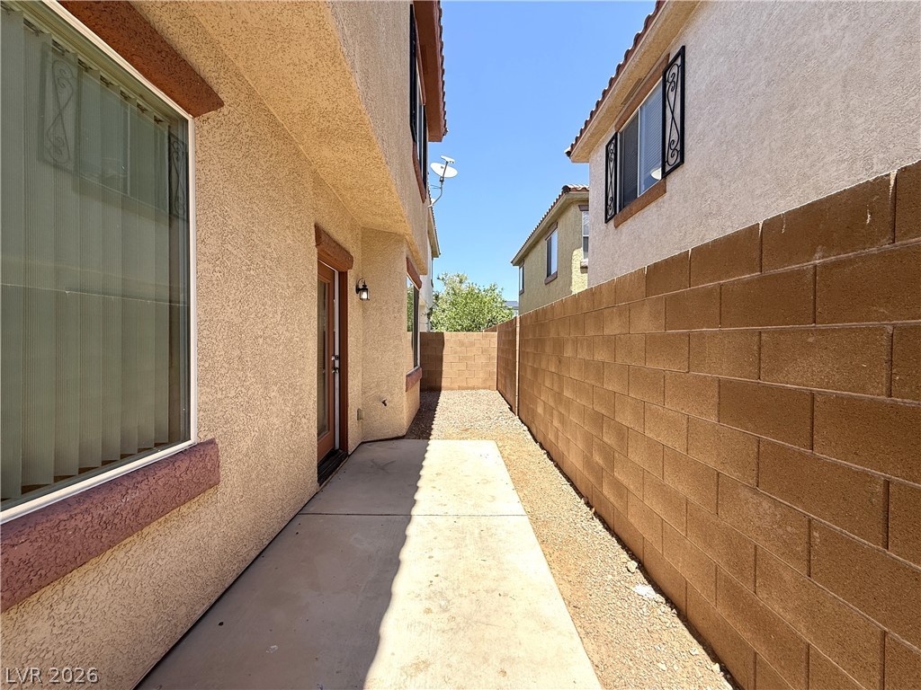 5942 Rampolla Drive Las Vegas, NV 89141 - Photo 27 of 27 A well-maintained side yard with a concrete walkway leads to a private outdoor space.