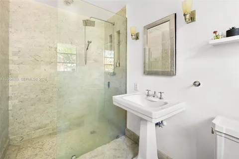a bathroom with a sink mirror and a shower