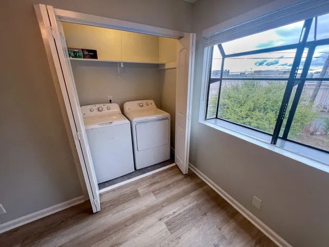 a utility room with wooden floor washer and dryer