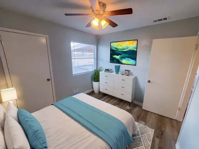 a bedroom with a bed and a flat tv screen on dresser