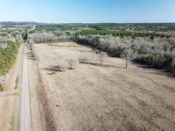 a view of a dry yard with wooden fence