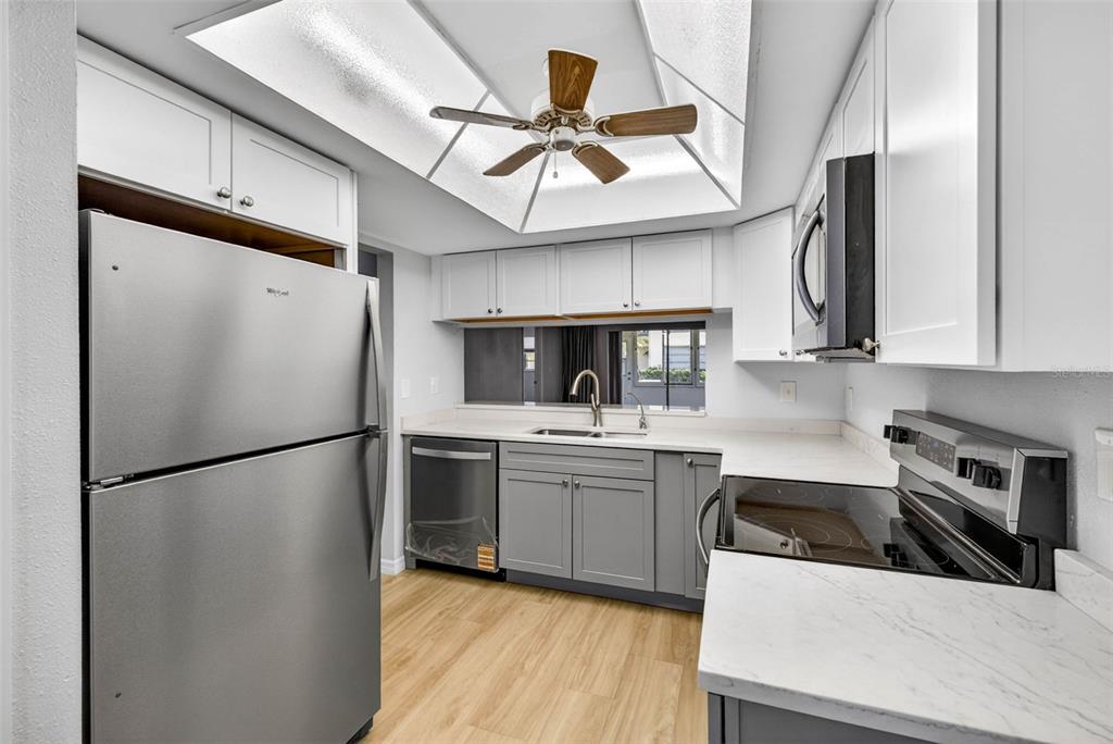 5197 Silent Loop, Unit 124 New Port Richey, FL 34652 - Photo 11 of 55 a kitchen with stainless steel appliances a refrigerator sink and cabinets