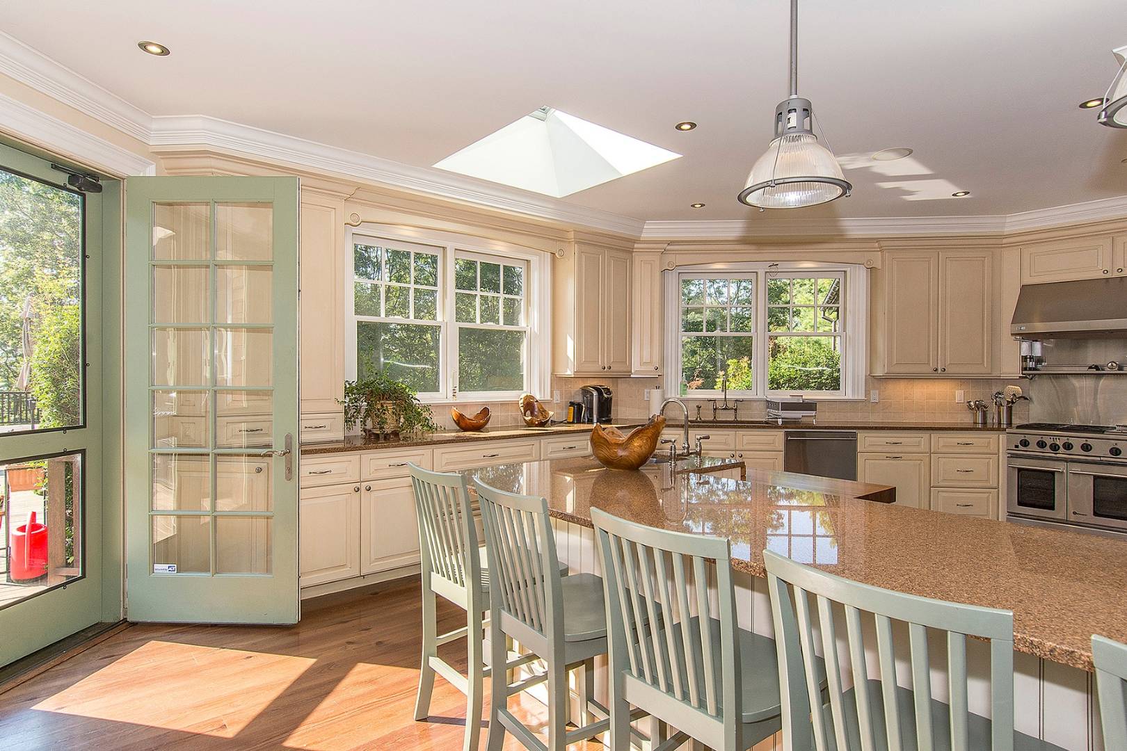 5 Highview Drive Wainscott, NY 11937 - Photo 5 of 20 a kitchen with stainless steel appliances granite countertop a stove a sink dishwasher a dining table and chairs with wooden floor
