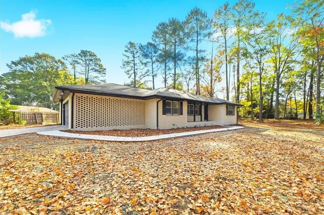 a white house that has a tree in front of it