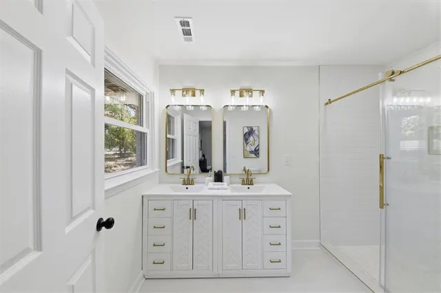 a bathroom with a double vanity sink a mirror a bathtub and shower