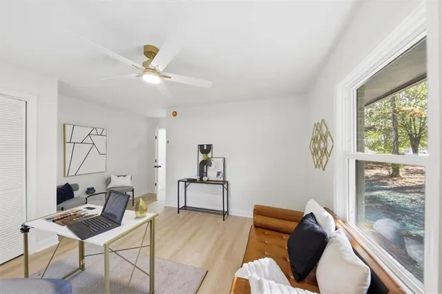 a living room with furniture a ceiling fan and a window
