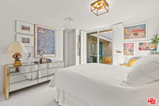 a bedroom with bed and glass door