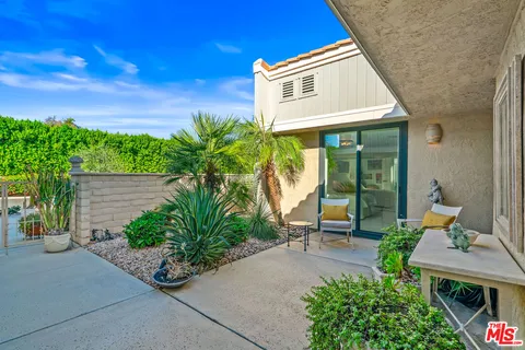 a view of a patio with dining table and chairs potted plants with wooden floor