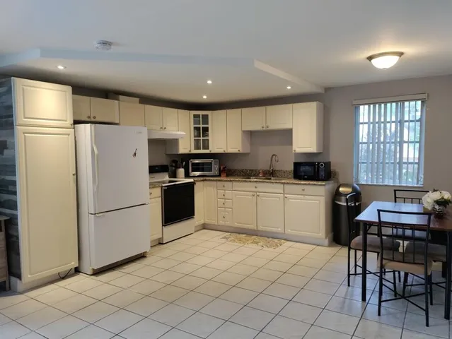 a kitchen with a refrigerator a table and chairs