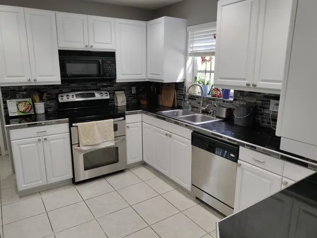 a kitchen with white cabinets and white appliances