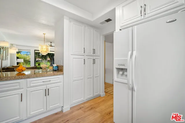 a kitchen with white cabinets and sink