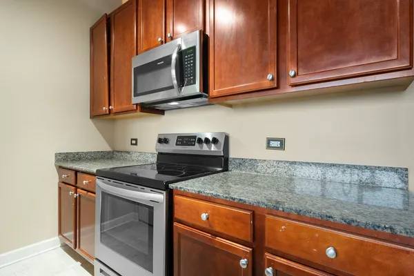 a kitchen with stainless steel appliances granite countertop a sink stove and microwave