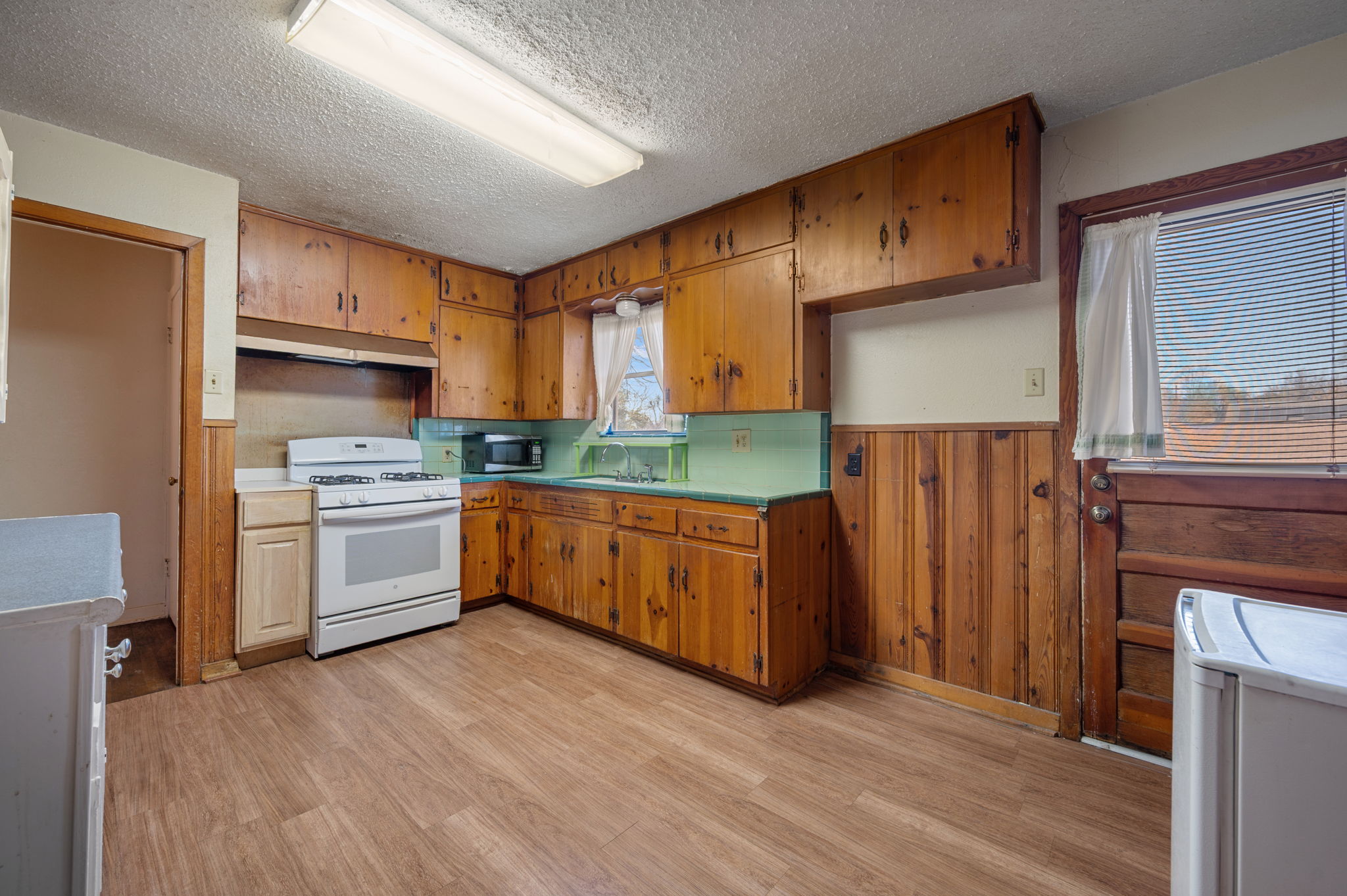 2000 Cedar Avenue Austin, TX 78722 - Photo 6 of 22 a kitchen with granite countertop wooden floors stainless steel appliances and window