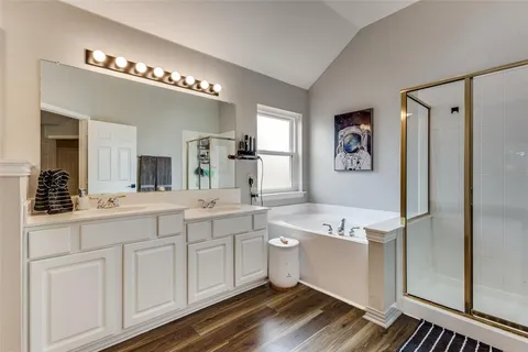 a spacious bathroom with a double vanity sink a mirror and a bathtub