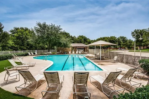 a view of yard with lawn chairs under an umbrella