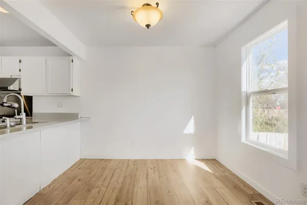 a view of a kitchen with wooden floor and a window