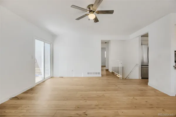a view of empty room with wooden floor