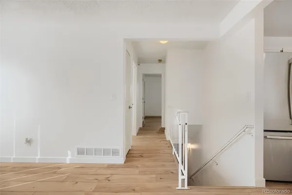 a view of a hallway with wooden floor and staircase