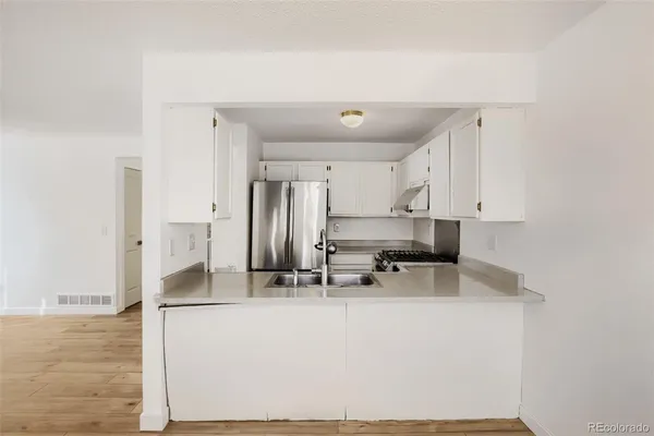 a kitchen with stainless steel appliances a sink stove and refrigerator