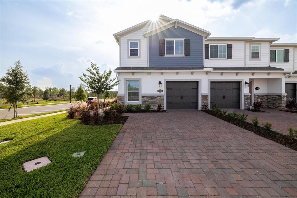 a front view of a house with a yard and trees