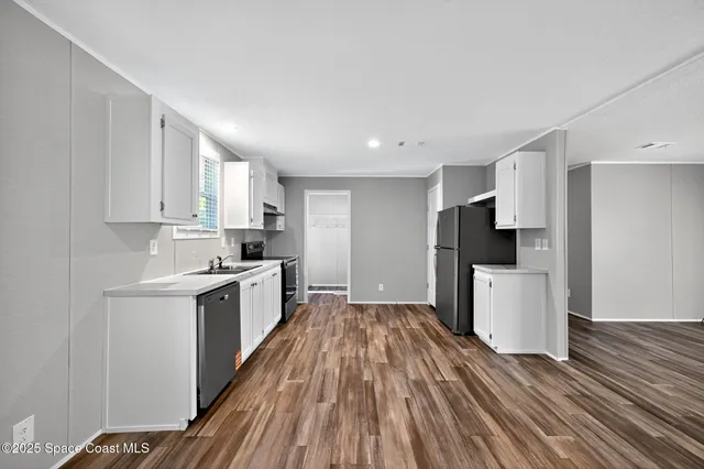 a kitchen with a refrigerator and a stove top oven