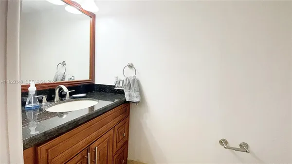 a bathroom with a granite countertop sink and a mirror
