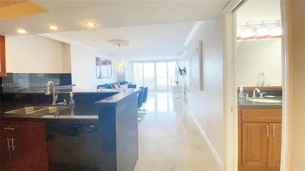 a kitchen with kitchen island granite countertop a sink stove and refrigerator