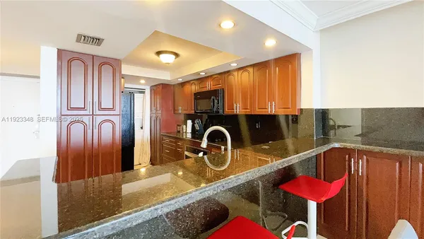 a kitchen with stainless steel appliances granite countertop a sink refrigerator and microwave