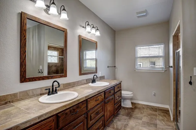 a bathroom with 2 sink and a mirror