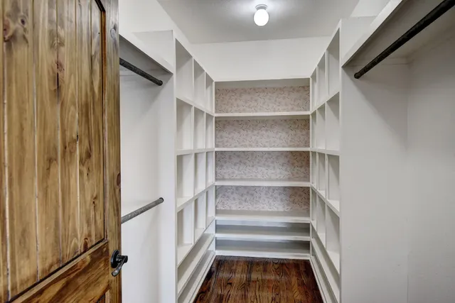 a view of walk in closet with empty racks