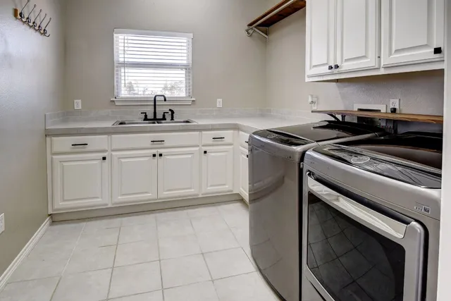 a kitchen with granite countertop white cabinets stainless steel appliances and sink
