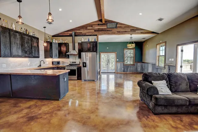 a large living room with stainless steel appliances granite countertop a couch and a view of living room