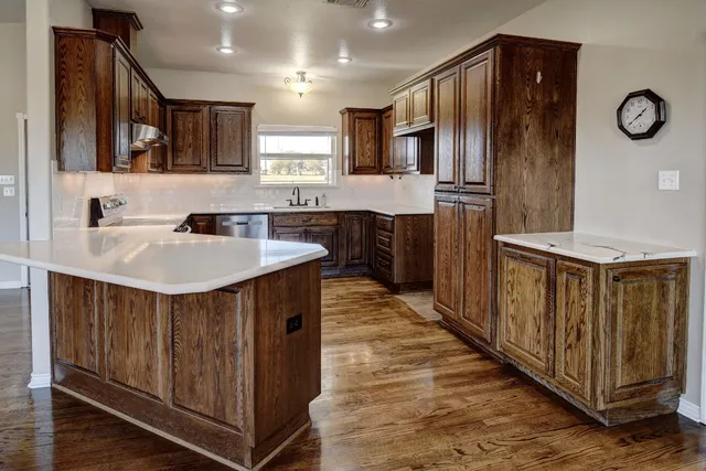 a kitchen with stainless steel appliances a sink cabinets and wooden floor