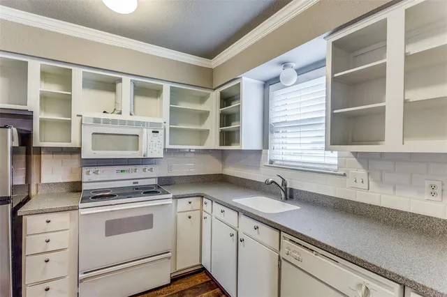 a kitchen with stainless steel appliances cabinets a large window and a sink