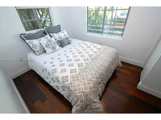 a bed sitting in a bedroom next to a window