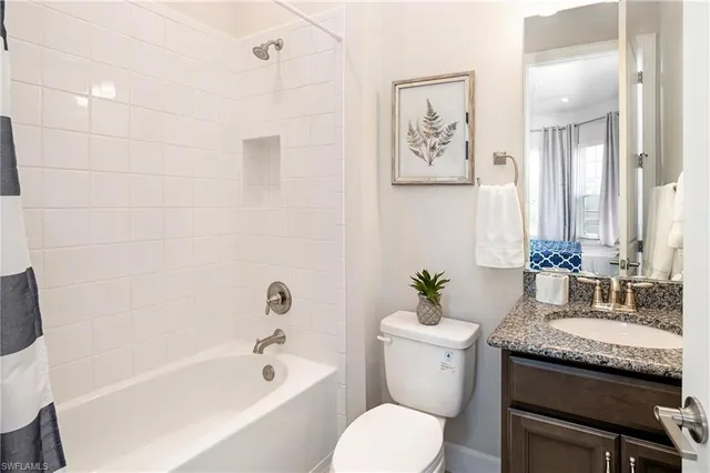 a bathroom with a granite countertop toilet a sink and a bathtub