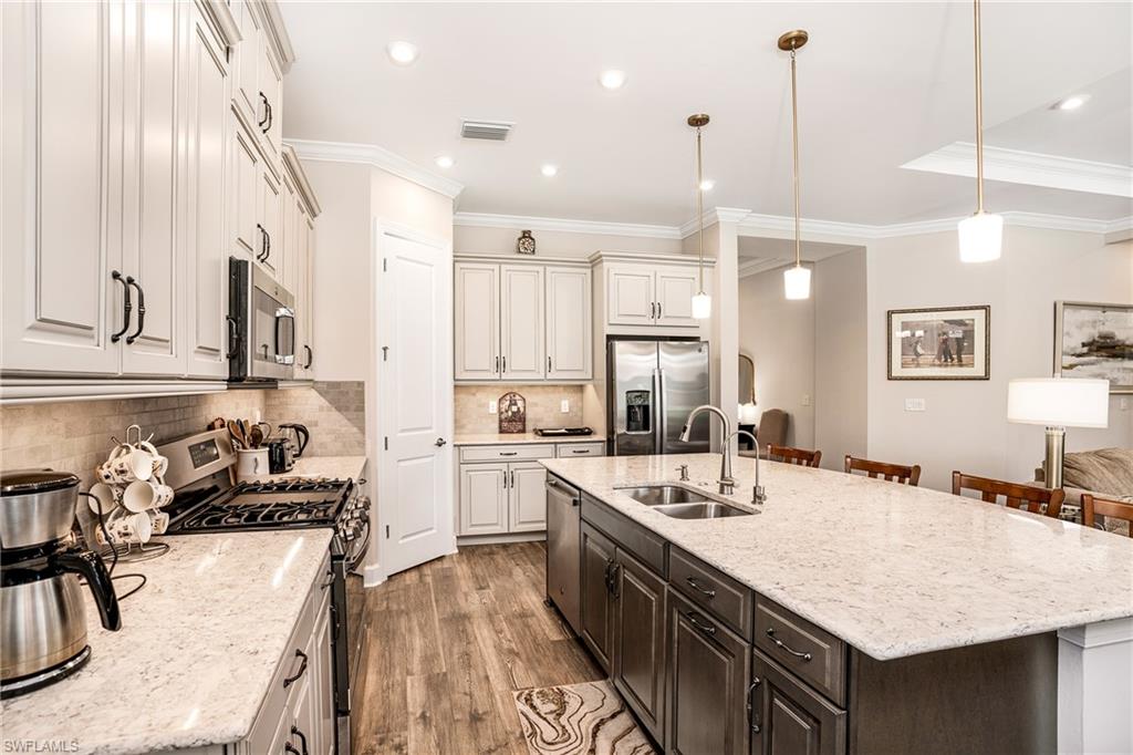 8131 Lucello Terrace North Naples, FL 34114 - Photo 3 of 32 a kitchen with counter top space a sink appliances and cabinets