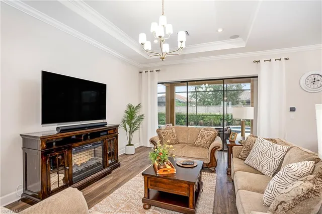 a living room with furniture a flat screen tv and a large window