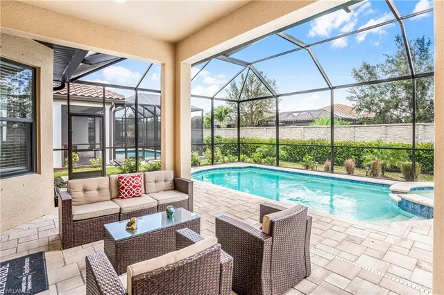 a living room with patio furniture and a garden
