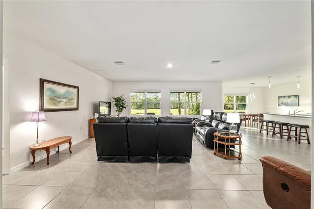 a living room with furniture a flat screen tv and a window