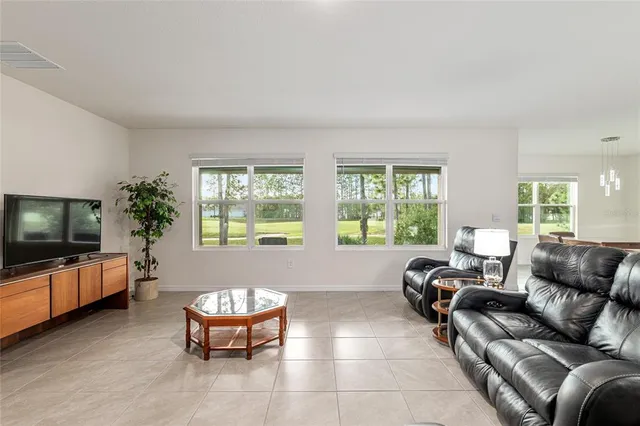 a kitchen with stainless steel appliances granite countertop a stove top oven a sink dishwasher a dining table and chairs with wooden floor