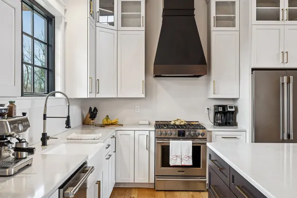 a kitchen with stainless steel appliances a stove a sink a refrigerator and cabinets