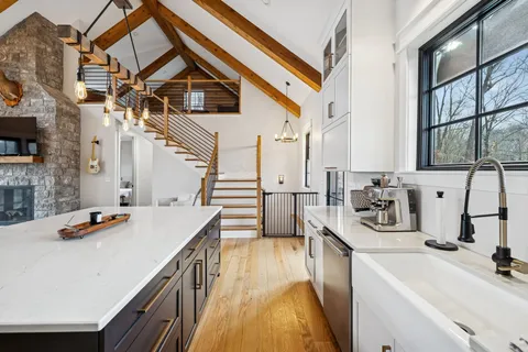 a kitchen with stainless steel appliances a sink a stove and a wooden floors