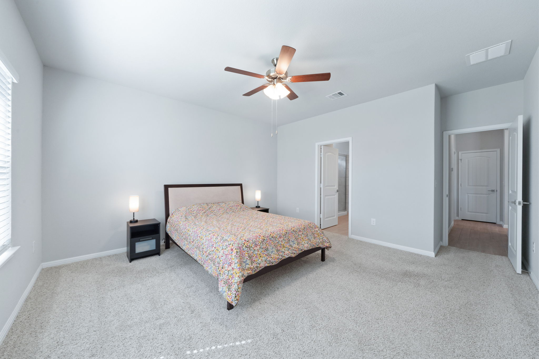 2412 Starhill Ranch Street Georgetown, TX 78628 - Photo 23 of 40 A tranquil primary bedroom with plush carpeting and a versatile ceiling fan for ultimate comfort.