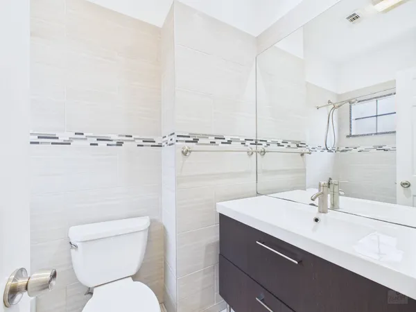 a bathroom with a sink mirror vanity and toilet