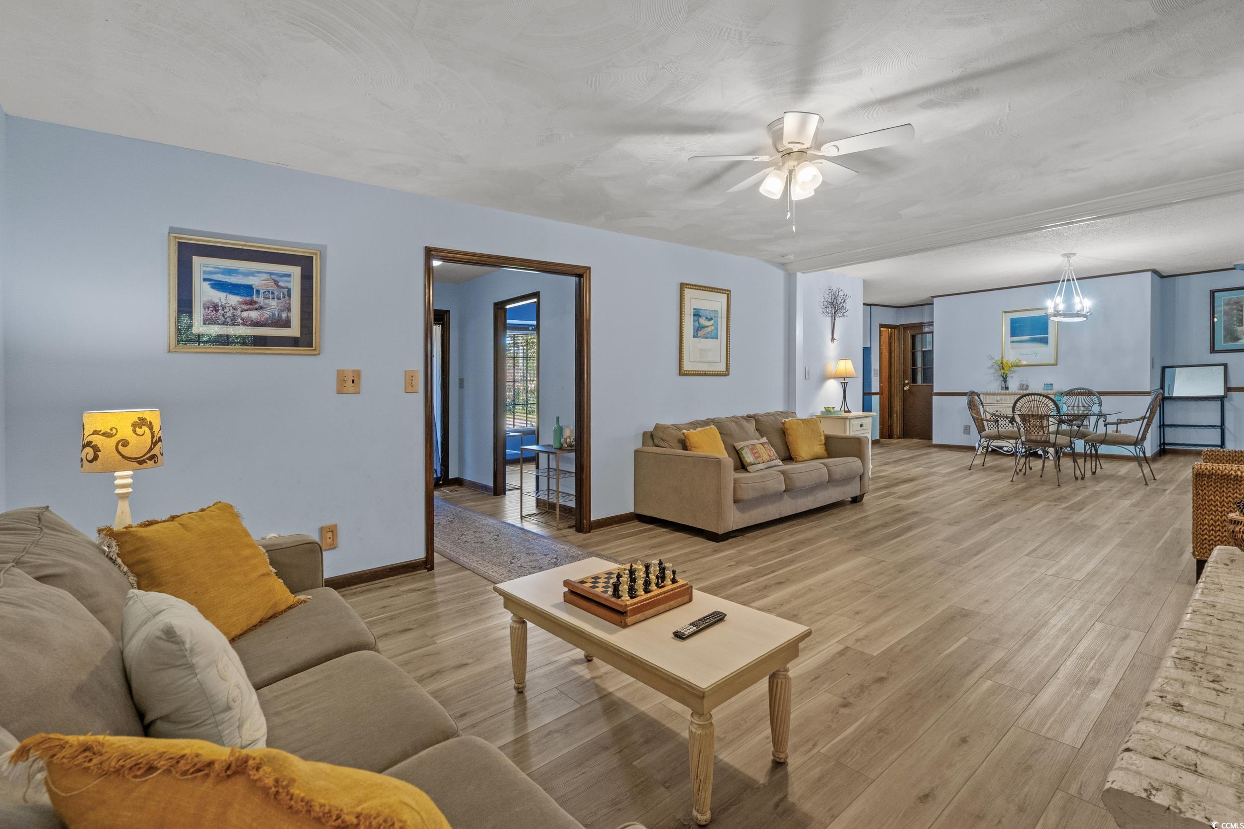1063 Burcale Road Myrtle Beach, SC 29579 - Photo 11 of 36 Living area featuring a ceiling fan, light wood-type flooring, and a chandelier