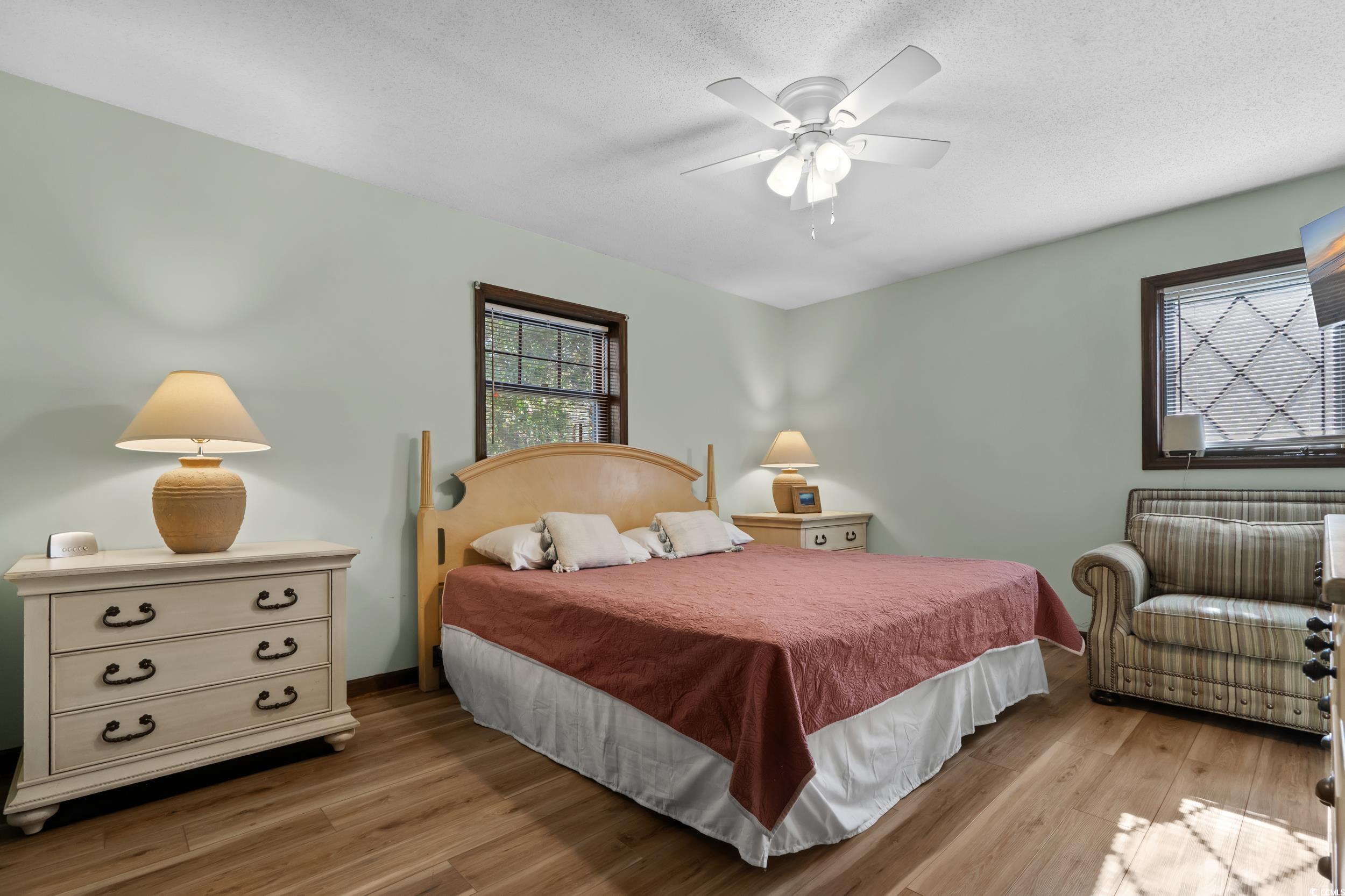 1063 Burcale Road Myrtle Beach, SC 29579 - Photo 24 of 36 Bedroom with light wood-type flooring, a ceiling fan, and a textured ceiling