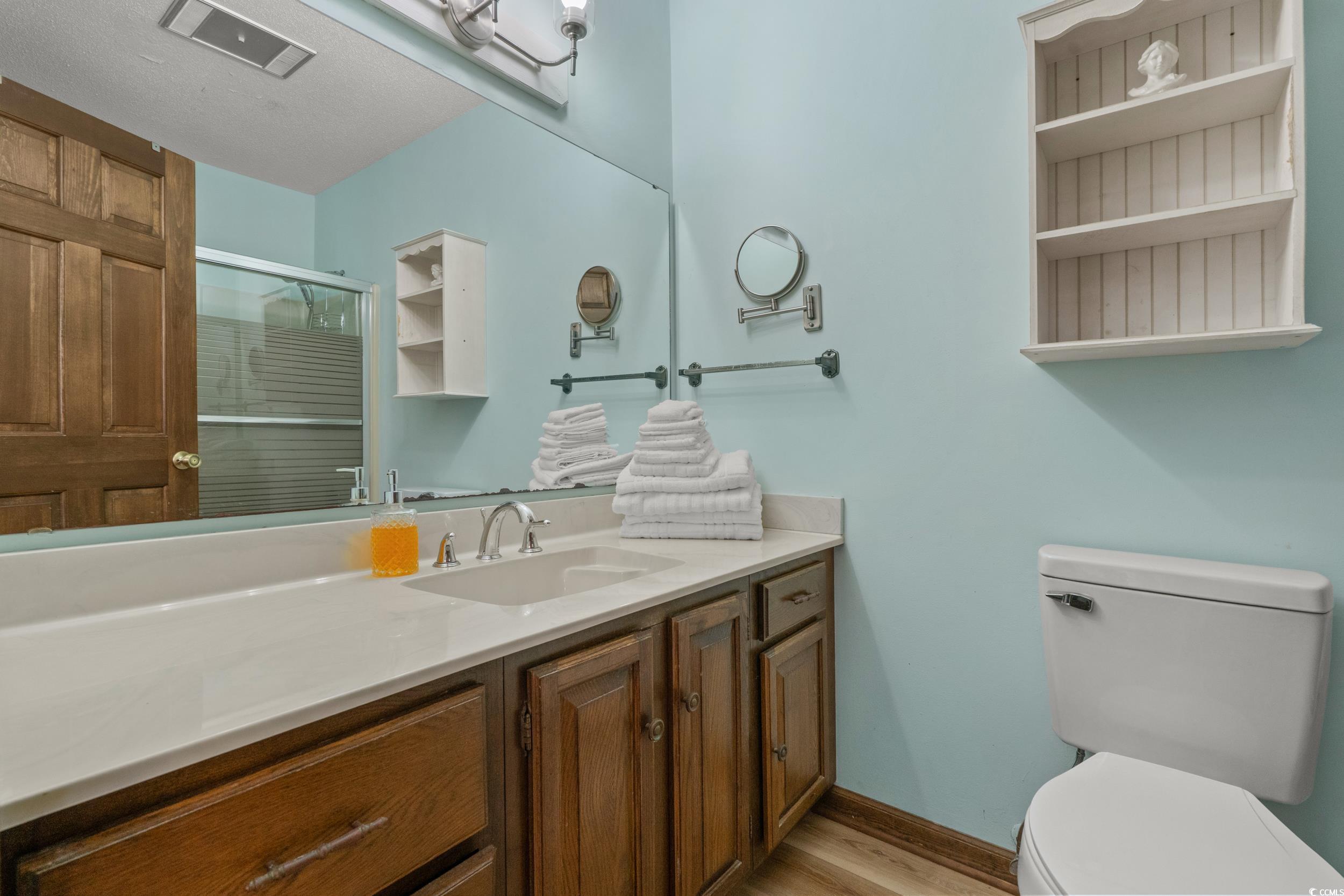 1063 Burcale Road Myrtle Beach, SC 29579 - Photo 27 of 36 Bathroom with a shower stall, vanity, and light wood-style floors