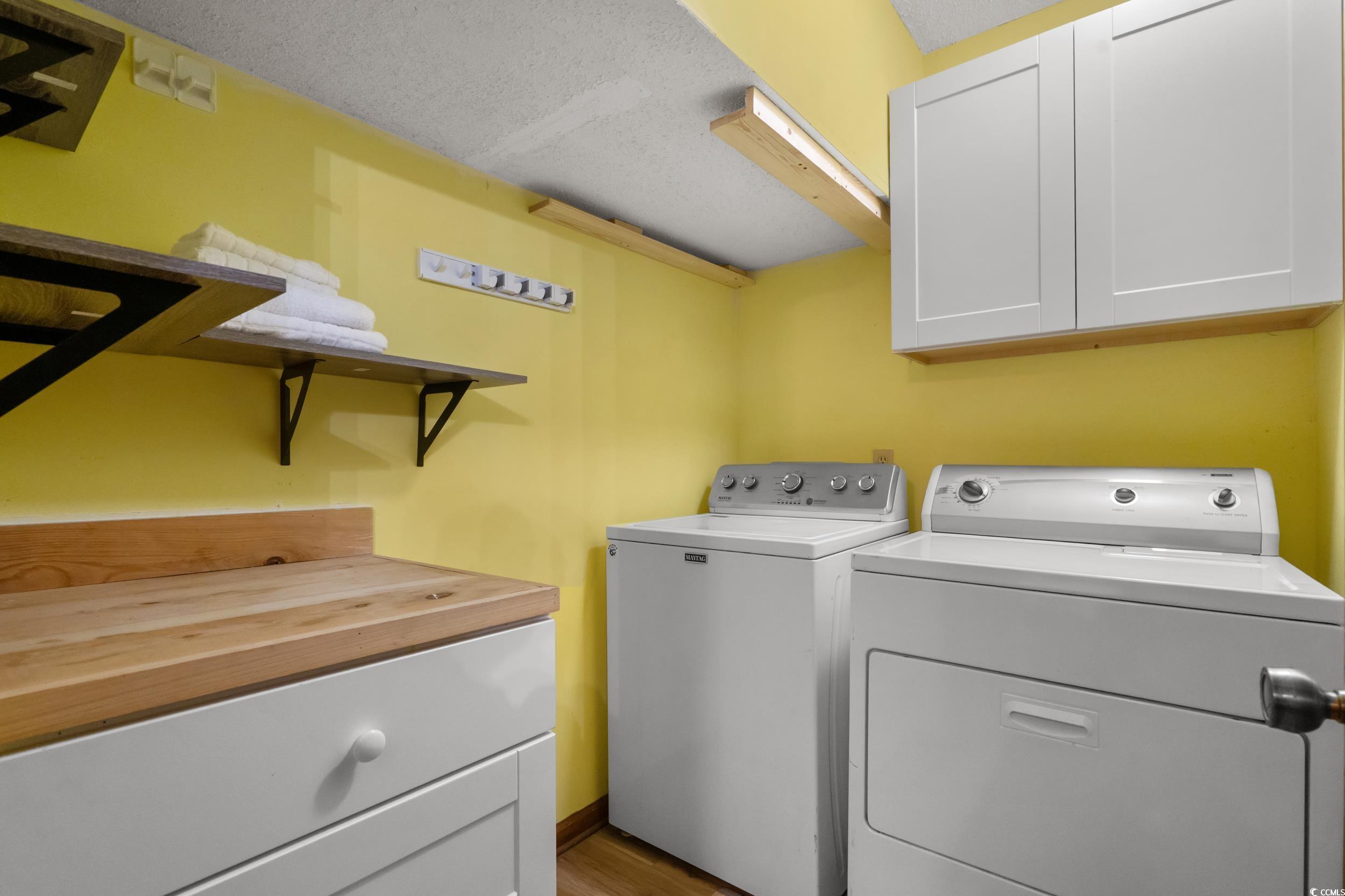 1063 Burcale Road Myrtle Beach, SC 29579 - Photo 34 of 36 Laundry room featuring cabinet space, washing machine and dryer, a textured ceiling, and light wood-style flooring