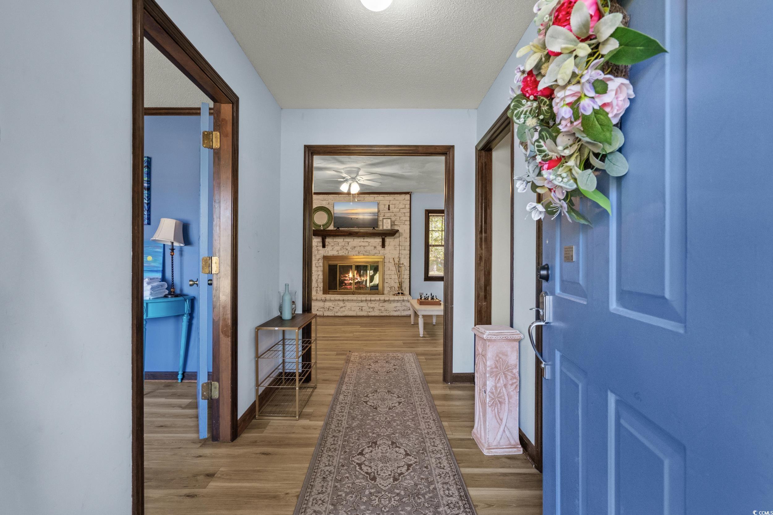 1063 Burcale Road Myrtle Beach, SC 29579 - Photo 8 of 36 Foyer entrance with light wood-style flooring, a textured ceiling, and a fireplace